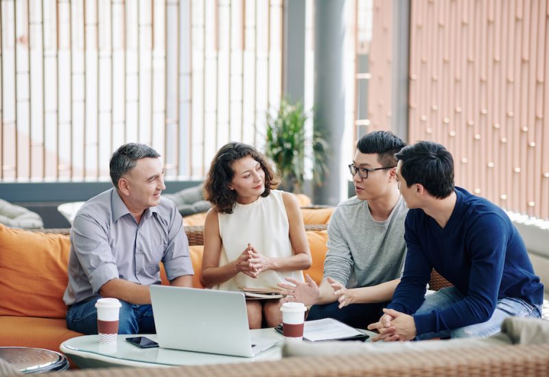 Business people looking at colleague sharing creative ideas at meeting