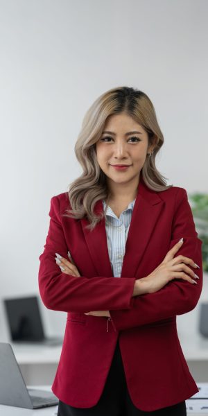 Cheerful and confident Asian businesswoman While sitting cross arms at the desk Paperwork in preparation for a meeting at modern workplace.